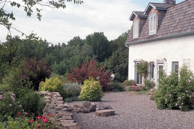 The whitewashed stone walls of the house, gravel pathways, and stone walls lend a Mediterranean aura to the Mono farmhouse. Photos by Malcolm Batty.