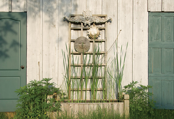 A trellis of reclaimed wood and a smattering of garden art lifts the eye upwards. Photo by Pete Paterson.