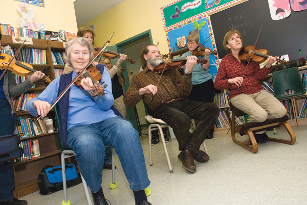 Sue Meggs, Peter Cole, Barb Terrett and Nancy Urekar (above, foreground) and Sam Nassey (left) brush up on their fiddle techniques at a recent weekend workshop held by Bill Elliott at The Maples near Orangeville. Photo by Tom Partlett.