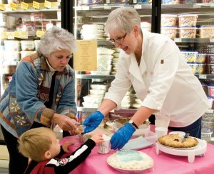 One of Jean Newell’s bakers, Sharon Flood (left), and her grandson Matthew visit Jean at the sampling table at Foodland in Caledon East. Photo by Pete Paterson.