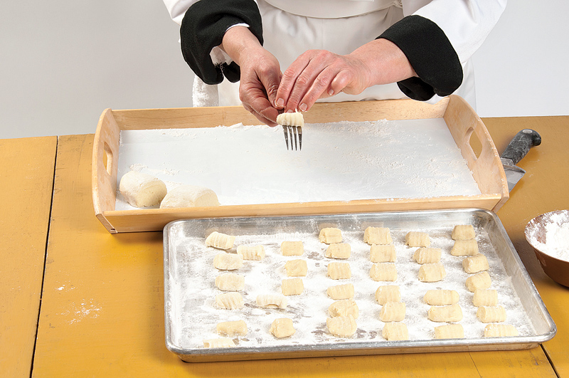 Roll each piece along the back of a floured fork to create a marked gnocchi. Or form into 1-inch balls and press with a floured thumb. Place the gnocchi on lightly floured baking sheets and cover with a clean tea towel. Chill for 3 hours before cooking. Photo by Pete Paterson