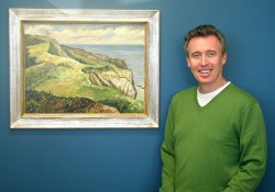 David Somers with “Cliffs and Sea, Mabou, Cape Breton,” oil on masonite, by Tom La Pierre (1930-2010). PAMA Permanent Collection.