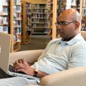 Anil Sharma takes advantage of the library’s Wi-Fi. Photo by Pete Paterson.