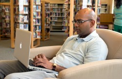 Anil Sharma takes advantage of the library’s Wi-Fi. Photo by Pete Paterson.