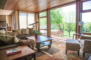 The living room overlooks the woods, a long lawn and boardwalk to the pond.