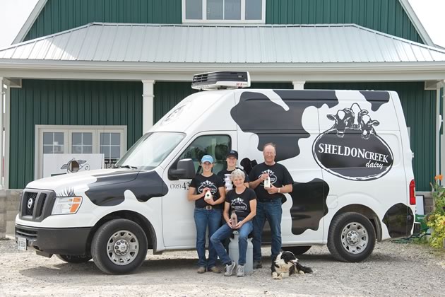 Sisters Emily and Marianne den Haan (left) with their parents John and Bonnie and dog Megs at Sheldon Creek Dairy, one of the first three dairies in Ontario since the 1960s licensed to sell their own whole milk direct from their farm. Photo by Pete Paterson.