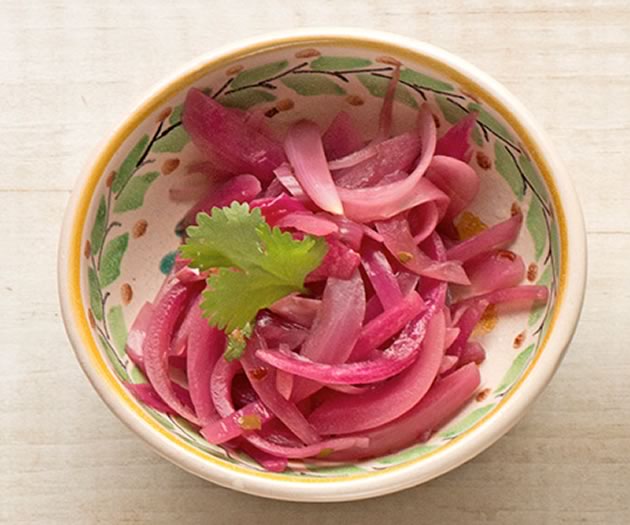 In a sauce pot, mix pickling spice, garlic, sugar, water and red wine vinegar. Bring to a boil. Remove from heat. Let cool for 5 minutes. Place red onions in a dish and pour pickling liquid over until just covered. Set the dish in the fridge for 10 minutes. Photo by Pete Paterson. Styling by Jane Fellows.
