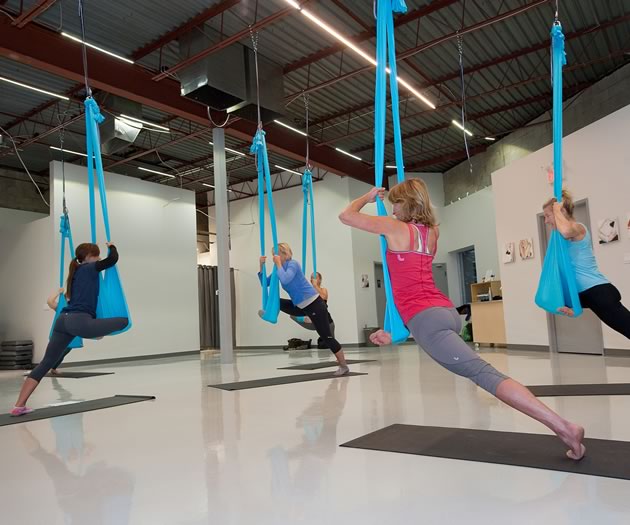 An aerial yoga workout, like this one at Personal Best in Mono Mills, combines yoga, Pilates and dance. The silk hammock allows for extra stretch and the occasional thrill of weightlessness. Photo by Rosemary Hasner / Black Dog Creative Arts.