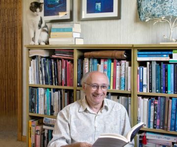 Dufferin poet laureate Harry Posner at home with his books and his cat Tweed: “It’s not my job merely to reflect local culture, but to stir it up a bit.” Photo by Pete Paterson.