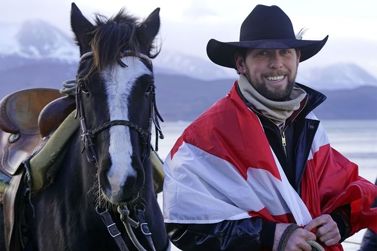 On the cold day Filipe Masetti Leite arrived on Pablo Picasso in Ushuaia at the tip of South America, he wrapped himself in a Canadian flag sent to him by Orangeville mayor Rob Adams. Photo by Barbara Nettleton.