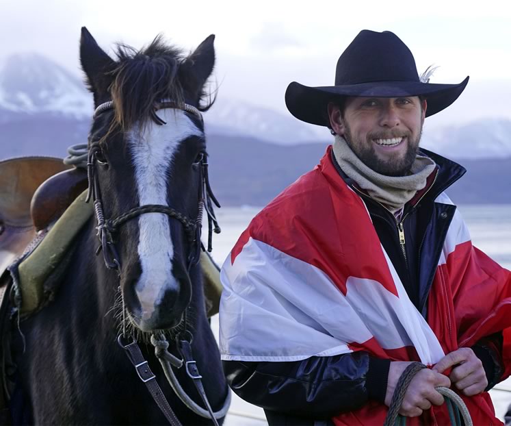 On the cold day Filipe Masetti Leite arrived on Pablo Picasso in Ushuaia at the tip of South America, he wrapped himself in a Canadian flag sent to him by Orangeville mayor Rob Adams. Photo by Barbara Nettleton.