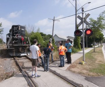 On the final run of the Cando Rail Services locomotive on June 29, the train pauses in Streetsville where engineer Steve Bradley and conductor Steve Thomas reminisce with railfans and allow them to take photos to mark the occasion. Photo by Warren Schlote.