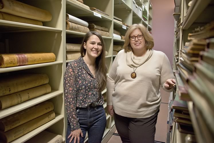 Curator Sarah Robinson (left) and archivist Laura Camilleri between the rolling shelves that house historic documents in the Museum of Dufferin. Laura and Sarah encourage people to talk to them about possible museum donations. “It’s the stories that help us decide what’s vital,” says Sarah. Photo by Pete Paterson.