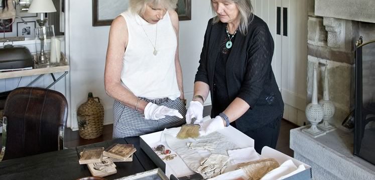 Robin works with archivist Alison Hird to document the Howard family heirlooms and papers in the dining room of her Caledon home. Photo by Pete Paterson.