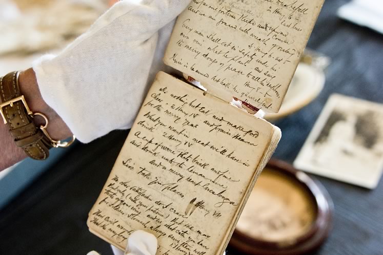 Robin wears white gloves to handle the leather journals her great-grandfather used as diaries and sketchbooks. Photo by Pete Paterson.