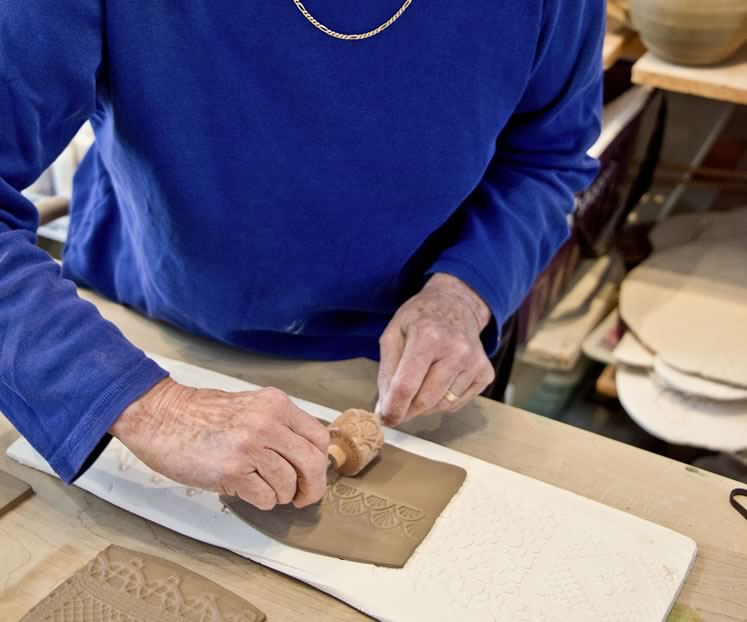 Mary Lazier creates one of her slab pottery bowls at her Mulmur studio. The intricate patterning is achieved using molds of vintage lace and wooden texture rollers. The bowl will be glazed in bluish white. Photo by Pete Paterson.