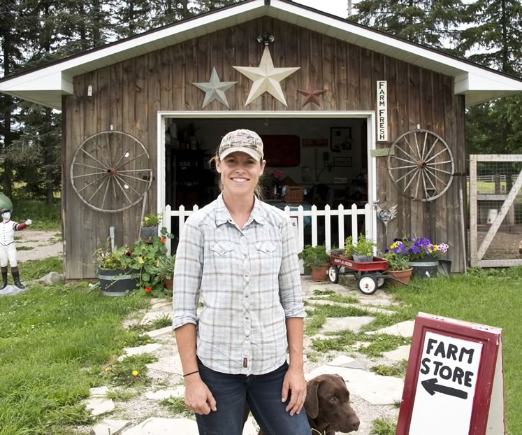 Rockcliffe Farm owner Alix Bezak in front of her on-farm shop with her chocolate lab, Goose. Photo by Pete Paterson.