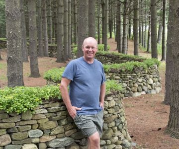 Dry stone waller Eric Landman stands on a private Caledon property where he has completed many walls and structures. Photo by Pete Paterson.