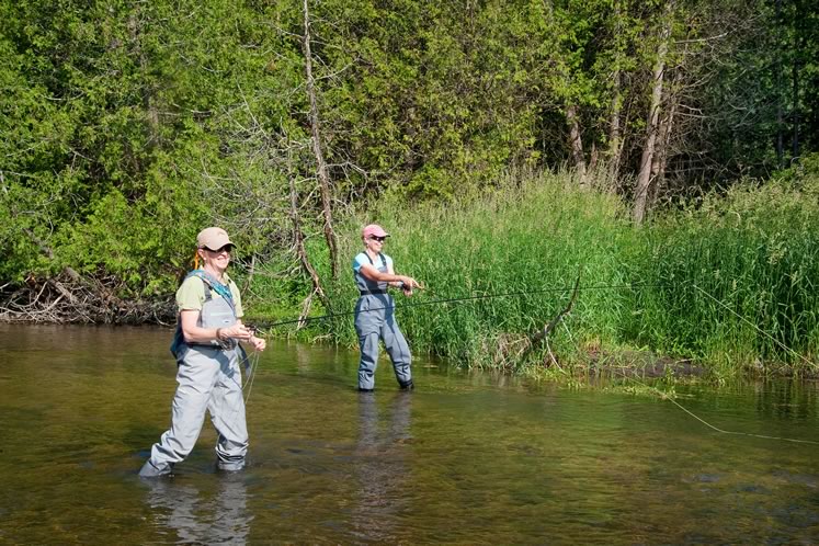 Avid flyfisher Susan Gesner (left) gives fishing novice Nicola Ross a casting lesson on the West Credit. Photo by Rosemary Hasner / Black Dog Creative Arts.