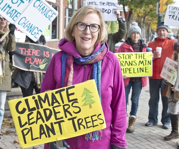 Activist Nancy Urekar has hoisted a sign and marched along Broadway in Orangeville every Friday at noon since January. Photo by Pete Paterson.