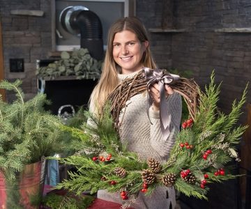 Florist Jessica Giovanatto holds one of the rustic, handmade Christmas wreaths she makes in her year-round workshop – the closed-in porch at the Caledon farm where she grew up. Photo by Pete Paterson.