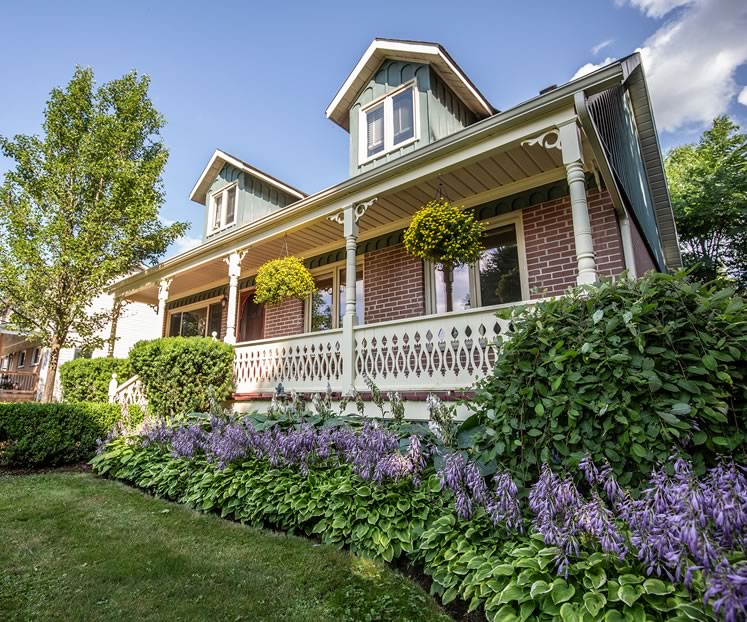 Tidy hedges and hostas frame the storybook Erin home Lia and Alex chose as their new nest. Photo by Erin Fitzgibbon.