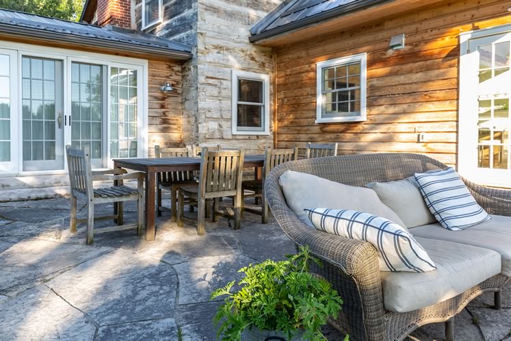 In the summer, the McLeans’ living space expands to include dining and seating areas on a stone deck. Photo by Erin Fitzgibbon.