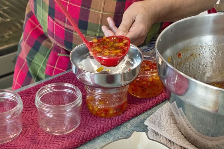 7 Take the pot of peppers off the heat, skim off any foam, then ladle into sterilized jars with finger-tightened lids. Photo by Pete Paterson.