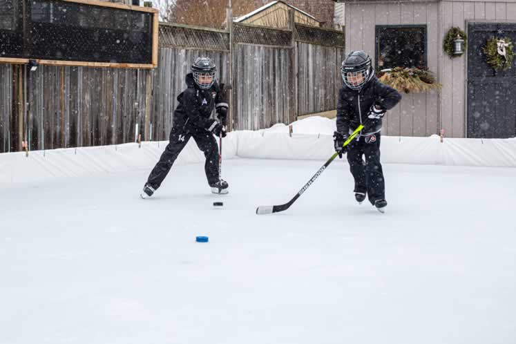 Zander and Nixon Alphonso hit the ice in the backyard of their Orangeville home. Photo by Erin Fitzgibbon. 