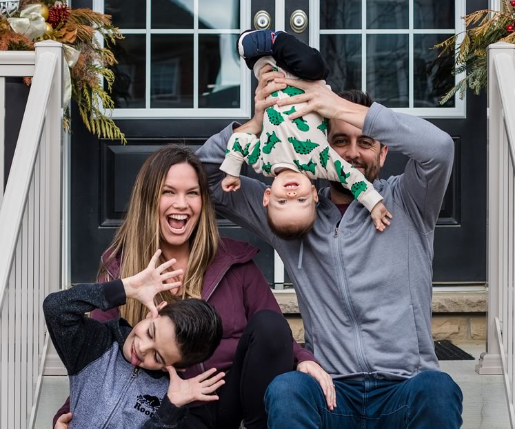 Candice and Rob MacPhee on their porch with sons Carter (left) and Finley. Photo by Nicole Lem.