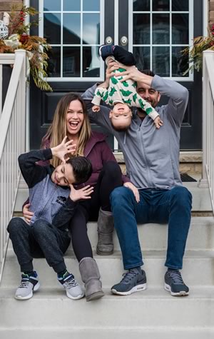Candice and Rob MacPhee on their porch with sons Carter (left) and Finley. Photo by Nicole Lem.