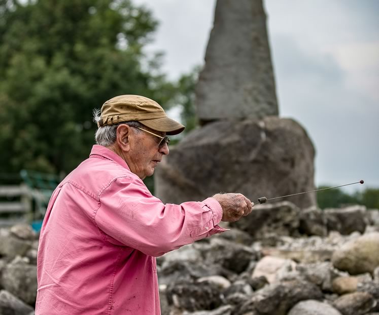 Joe Burchell uses a dowsing rod to commune with the energy of the Earth. Photo by Kerry Knudsen.