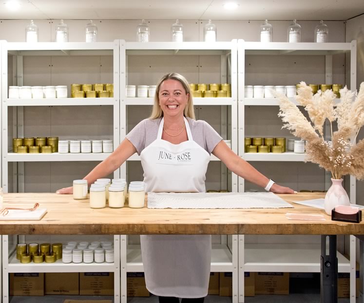 Candlemaker Melissa Lester in her pristine Caledon studio backed by tidy shelves of her handmade June + Rose Candle Co. products. Photo by Pete Paterson.