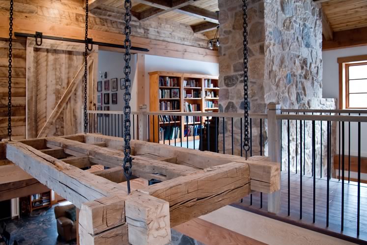 A view of a custom-made chandelier and the bridge connecting the two wings of the second floor. A reading nook is tucked behind the stone chimney. Photo by Rosemary Hasner / Black Dog Creative Arts.