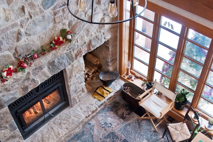 The massive fireplace and chimney were built using stones reclaimed from an old barn on the property, as well as some displaced when the foundation was dug for the new house and others collected at a family cottage. Photo by Rosemary Hasner / Black Dog Creative Arts.