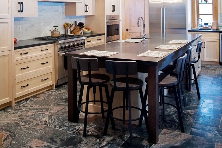 The generously proportioned kitchen features a dark Muskoka granite floor that absorbs the warmth of the winter sun, then radiates heat after the sun has set. Photo by Rosemary Hasner / Black Dog Creative Arts.