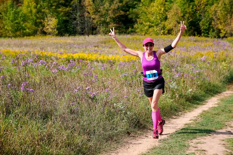 An enthusiastic runner is colour-co-ordinated with the wildflowers. Photo by Sue Sitki Race Photography.