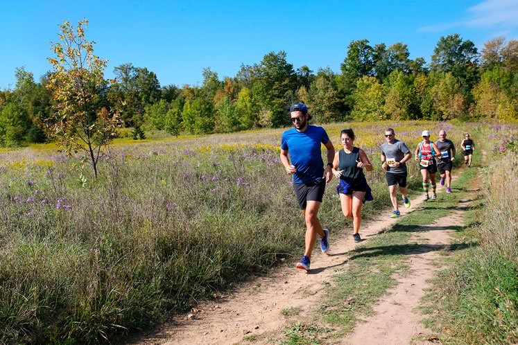 Participants traverse a field of asters and goldenrod. Photo by Sue Sitki Race Photography.