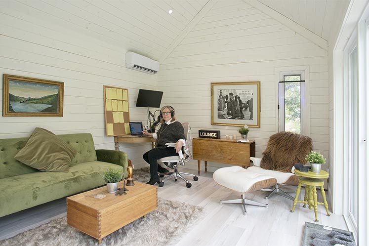 Brimstone writer and podcaster Liz Beatty at work in the backyard recording and work studio she had built in 2020. The Nordic-style cabin, top right, was designed and installed by Toronto-based prefab makers Summerwood Products. Photo by Pete Paterson.