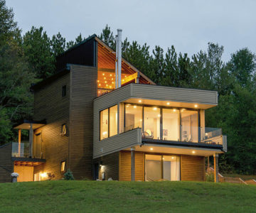 Architects Jan and Ivana Benda’s Mulmur home, Bluepine, sits on a slope against a forested backdrop.