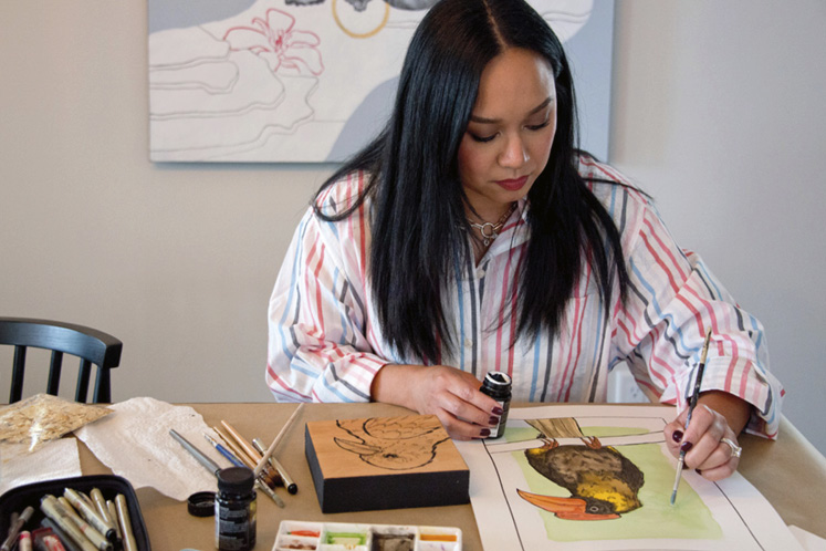 Stephanie Casino Esguerra adds gold leaf to one of her watercolour and ink pieces. Photography by Pete Paterson.