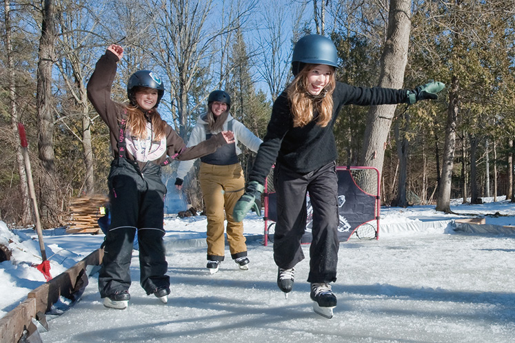 Family skates together on backyard rink in Ontario